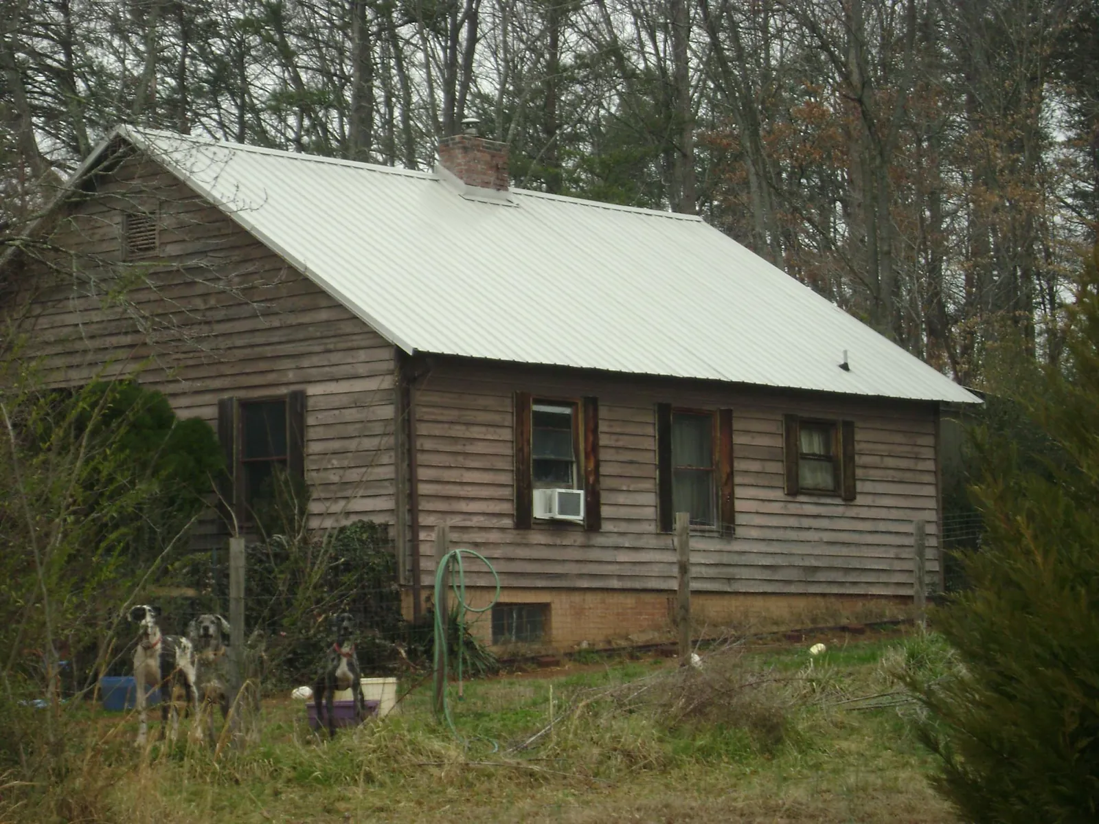 White metal roof on an old wood sided farmhouse, from a Metal Roof Installation job in Lawton